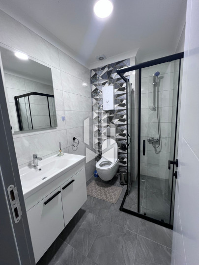 A cozy 1+1 apartment is for rent in a new and well-maintained complex in the Mahmutlar district 9